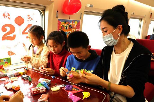 高铁列车上，家长带孩子在“遛娃舱”玩玩具。陈月摄