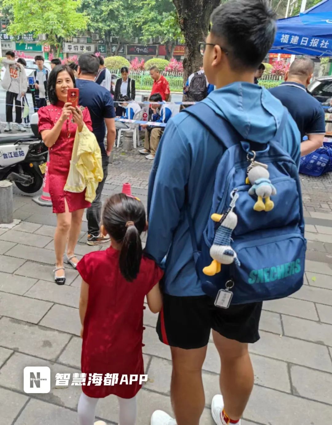 不少家长身穿红衣前来送考福州四中这位妈妈特地挑选了绿色旗袍,祝